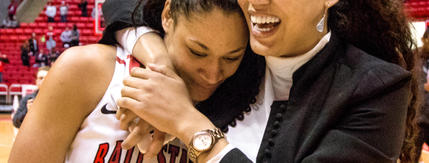 Photo shows Nathalie Fontaine getting a hug from her sister Sherie after Nathalie became the women’s basketball all-time career points leader in Worthen Arena.