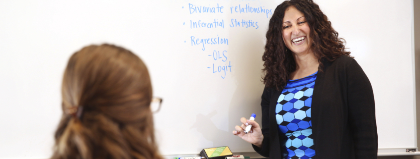 Serena Salloum, an assistant professor in the Department of Educational Leadership, talks with a student in a classroom.