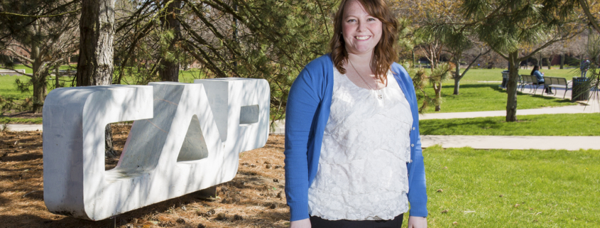 Leslie Adriance, a senior architecture major, stands near a sign for Ball State’s College of Architecture and Planning.