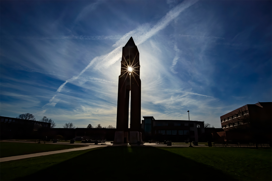 The sun peeks through an opening in the very tall Shafer Tower in the afternoon