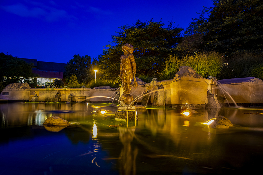 Frog Baby statue lit up at night