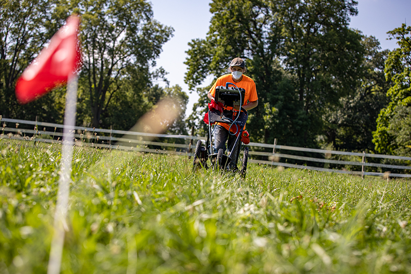 A Ball State archaeologist pushes ground-penetrating radar through a gravesite